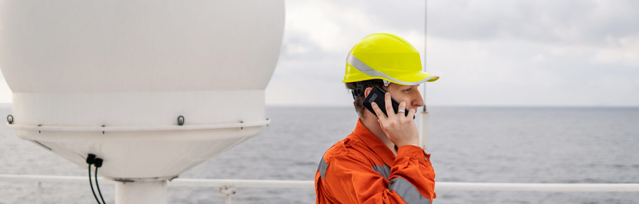 maritime worker helmet ship satellite antenna on the phone