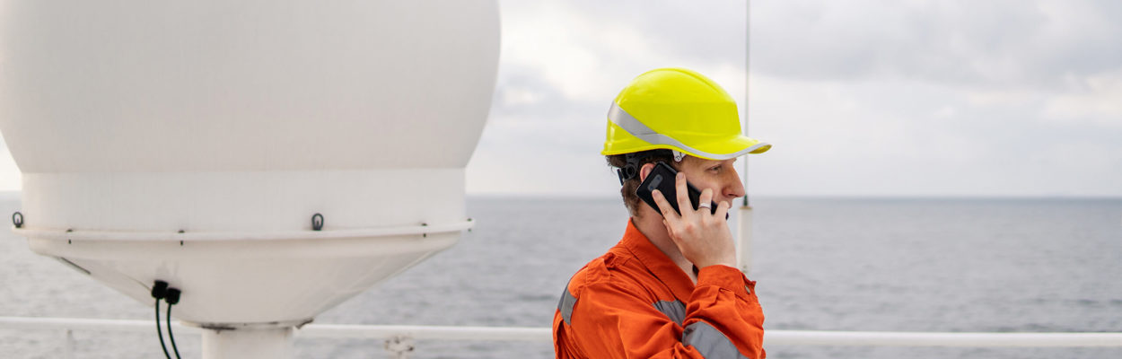 maritime worker helmet ship satellite antenna on the phone